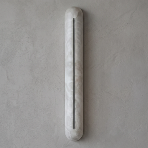 Hoailamp alabaster linear wall sconce unlit, showing the minimalist pill-shaped natural limestone body