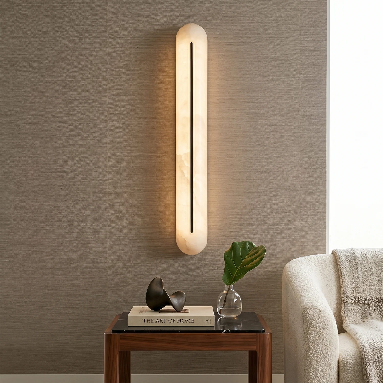 Alabaster Linear LED Wall Sconce by Hoailamp glowing warm white beside a sofa on a textured accent wall