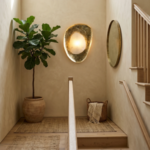 Hand crafted hammered metal lotus leaf wall sconce on hallway stairs wall