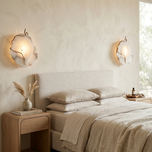 Hand-carved alabaster wall sconces glowing softly in a serene bedroom with neutral linens.
