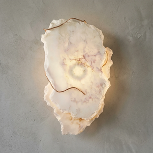 Hand-carved alabaster wall sconce with warm glow and natural stone texture, modern luxury lighting