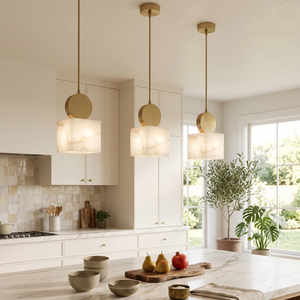Three alabaster mini pendants in a row above a white kitchen island