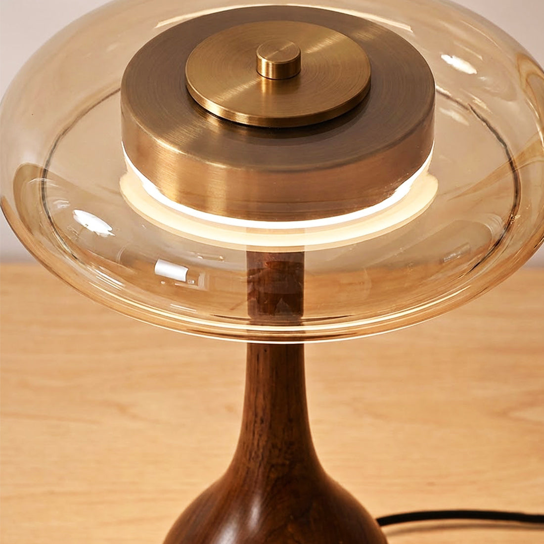 A close view of the hand-blown amber glass disc set into the lamp's frame.