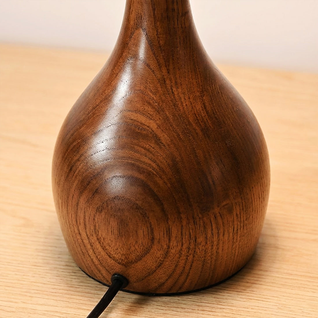 The solid wood arch of the lamp up close, showing its natural grain.