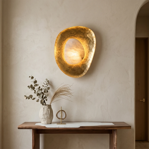 Hand crafted hammered metal lotus leaf wall sconce on wooden console table