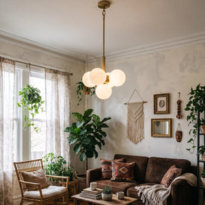 Illuminated Lune chandelier above a living room coffee table beside a sofa
