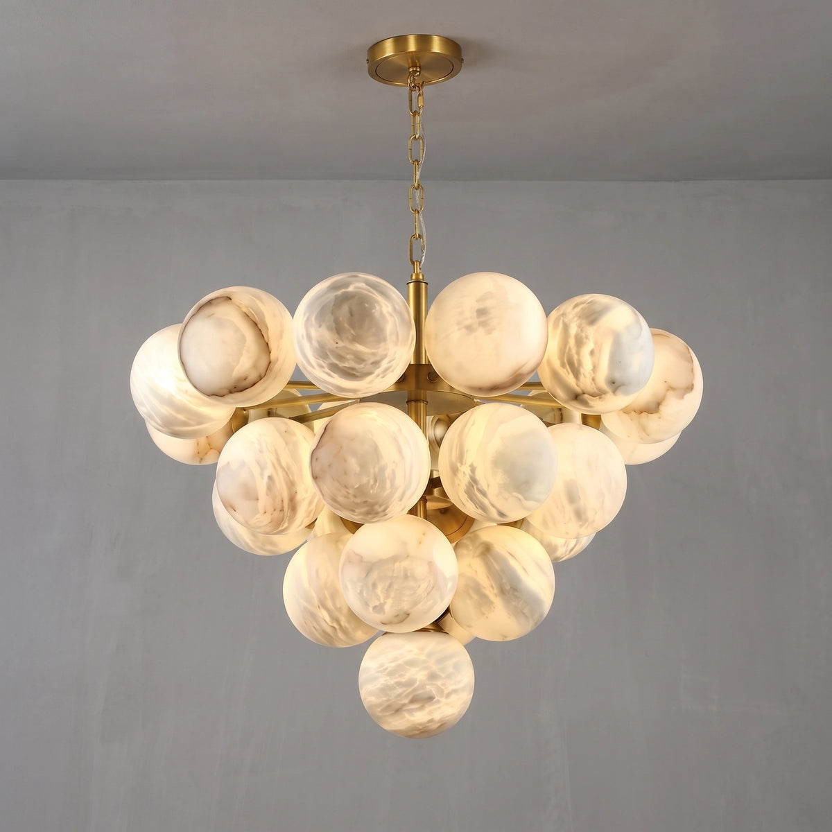 Illuminated large Lune chandelier suspended from a brass chain