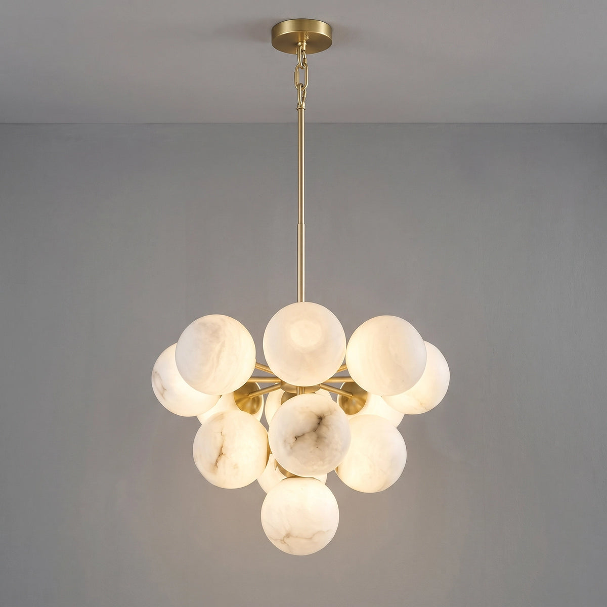 Illuminated medium Lune chandelier suspended from a brass rod