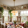 Lune alabaster cluster chandelier illuminated above a dining table beside windows