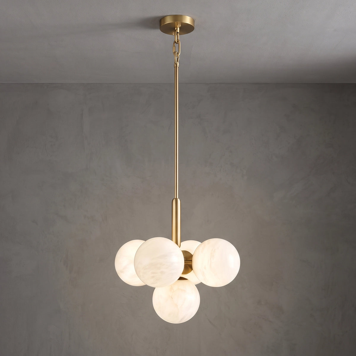 Illuminated small Lune chandelier suspended from a brass rod