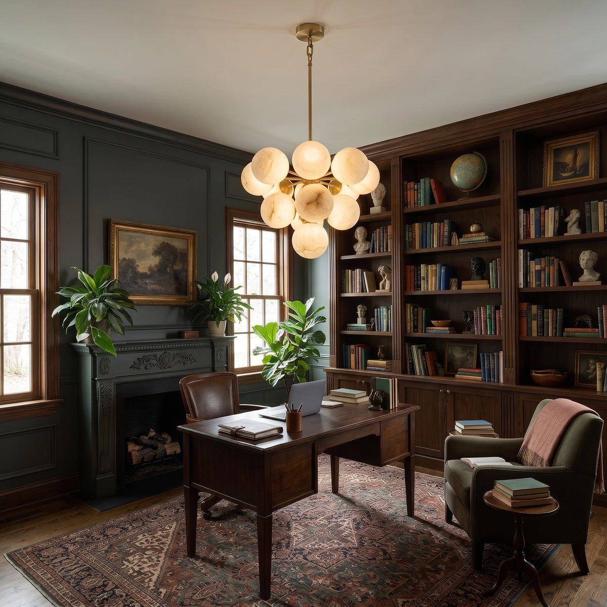 Illuminated Lune chandelier above a desk in a room with bookshelves