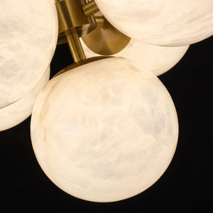 Close-up of illuminated Lune alabaster globes and brass fittings