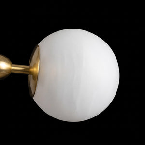 Unlit white alabaster globe on a brass arm against a dark background