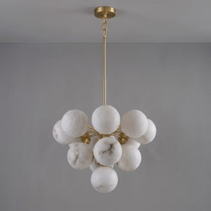 Unlit medium Lune chandelier suspended from a brass rod