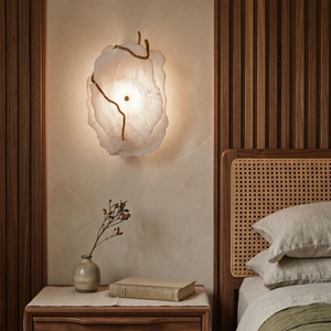 Hand-carved alabaster wall sconce with warm glow, modern bedroom lighting, brass accents, natural stone texture