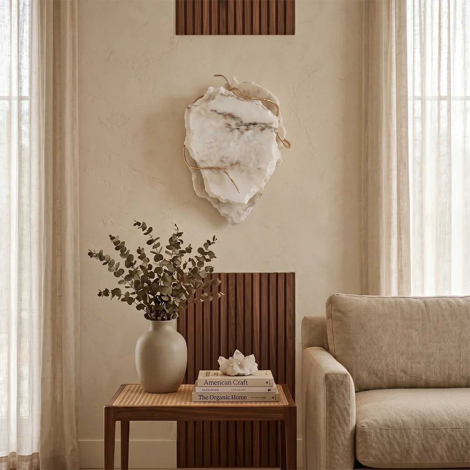 Hand-carved alabaster wall sconce with gold accents, glowing softly in a modern living room.