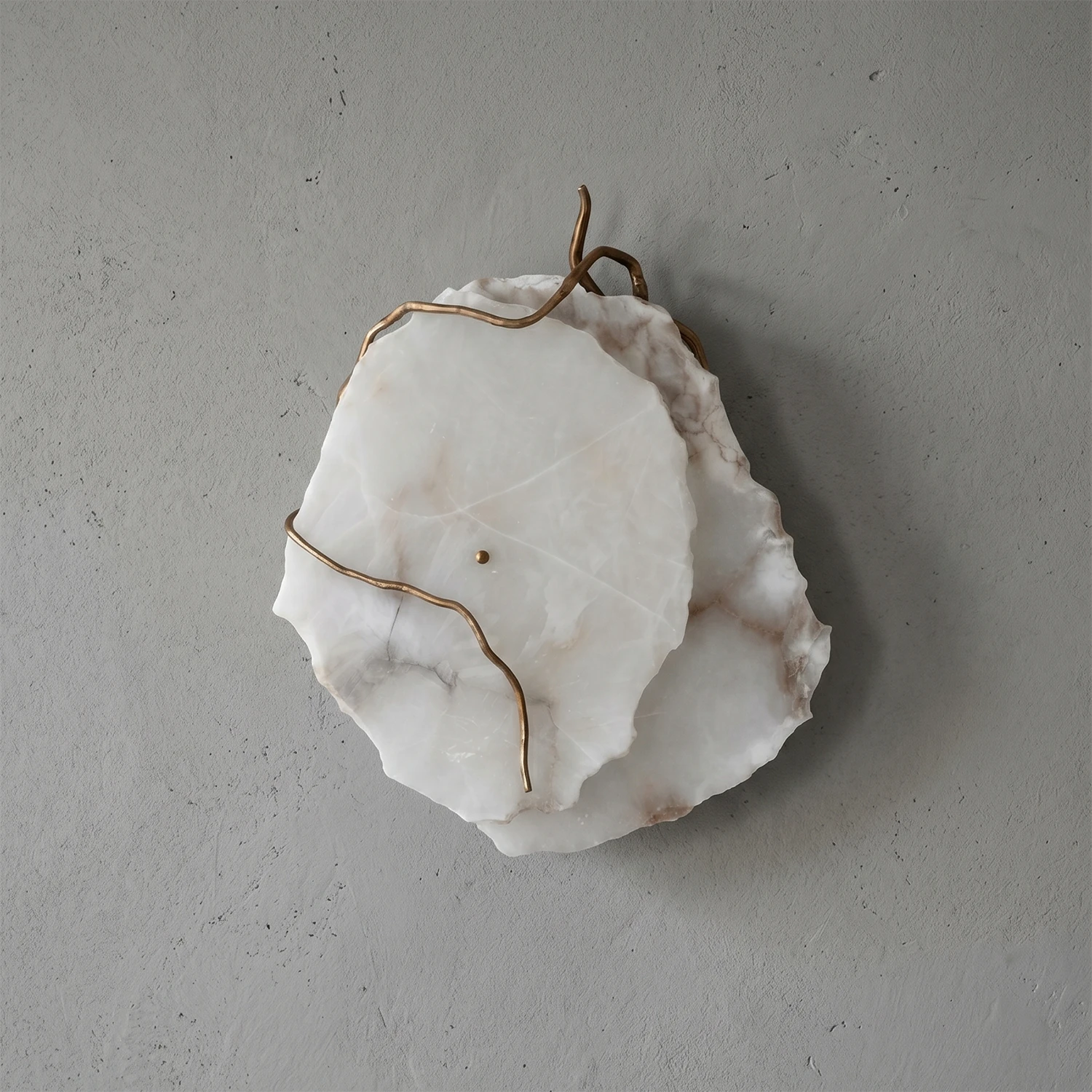 Hand-carved alabaster wall sconce with brass wire accents, modern organic design for ambient lighting