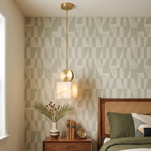 Perrin alabaster mini pendant hanging beside a bedside table against patterned wallpaper