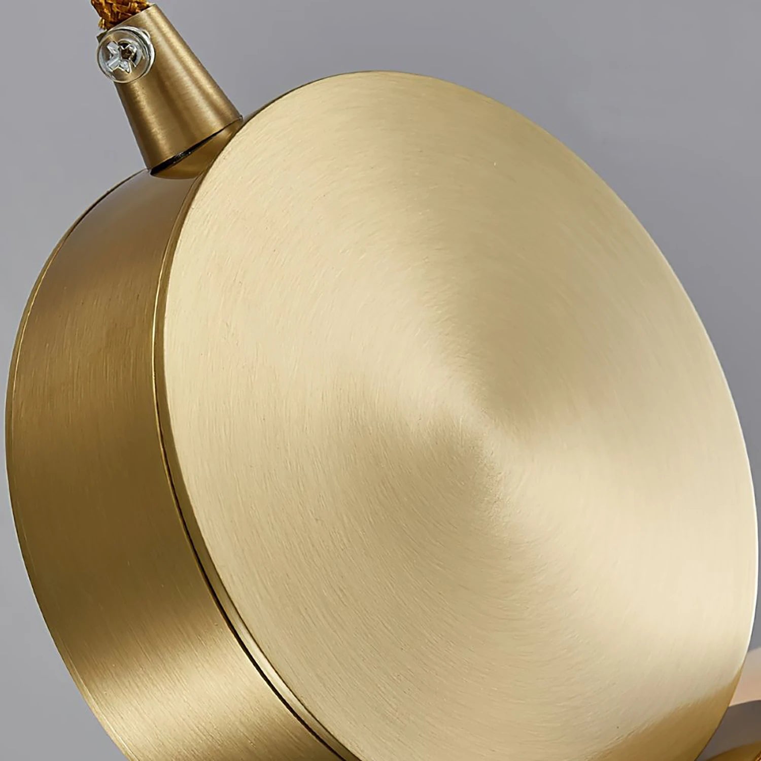 Close-up of the hand-brushed brass disc that caps the alabaster shade
