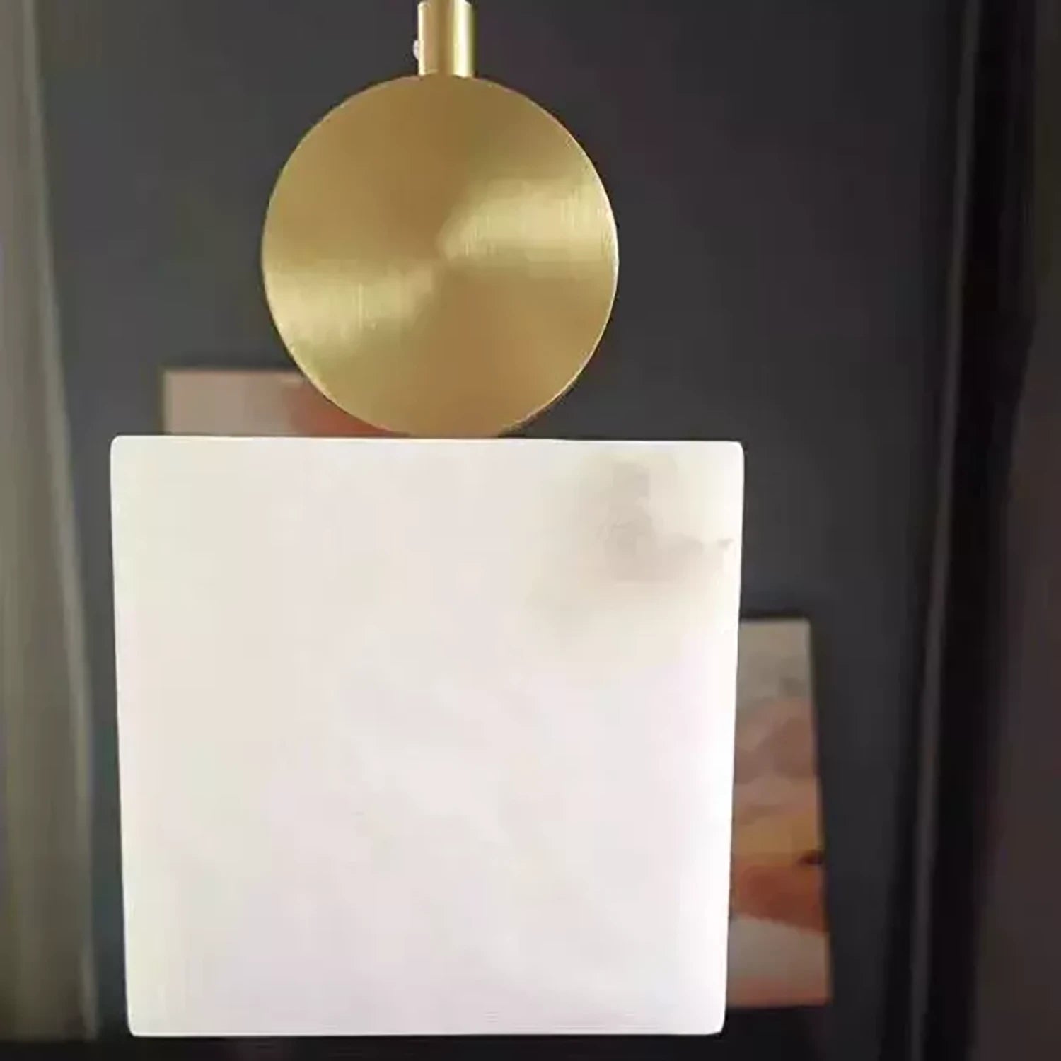 Illuminated cube alabaster shade glowing honey-gold against a dark background