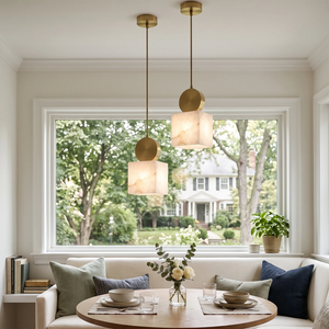 Two brass-capped alabaster pendants over a dining nook beside a window